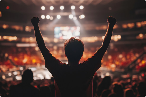 sports arena with fan standing up with hands up cheering