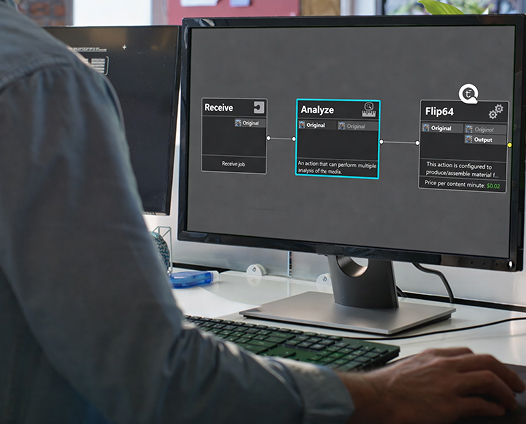 Person working on a computer screen displaying workflow steps for media analysis and processing automation