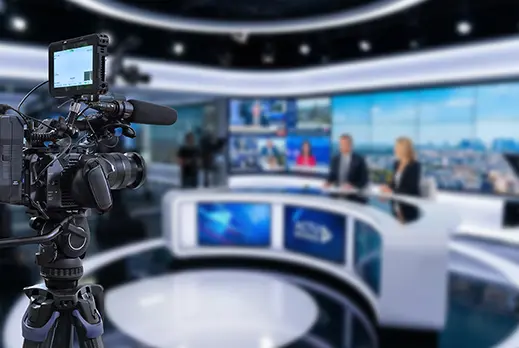 modern news broadcast studio with camera and news desk